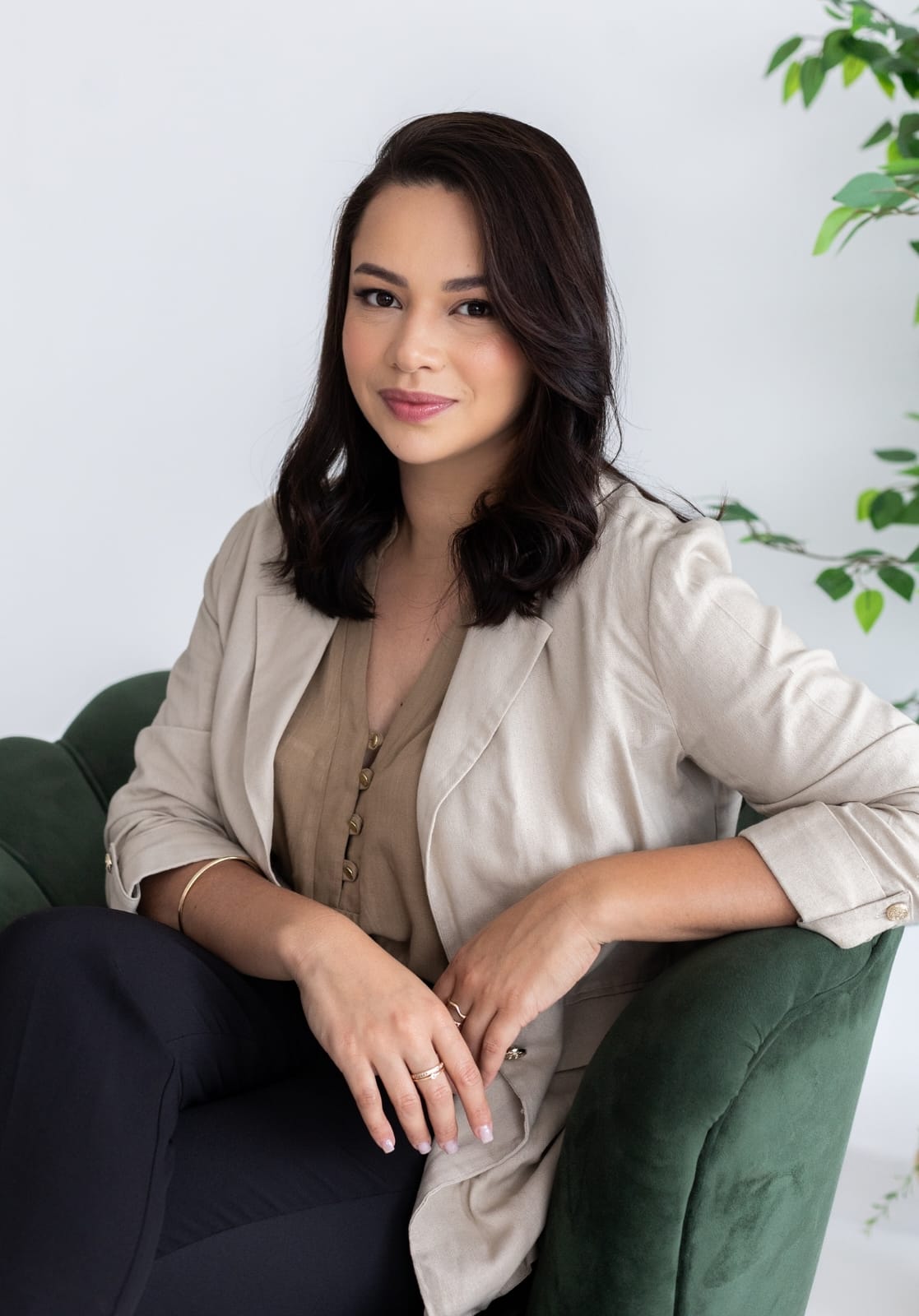 Leidiane Vianna sentada em uma poltrona verde